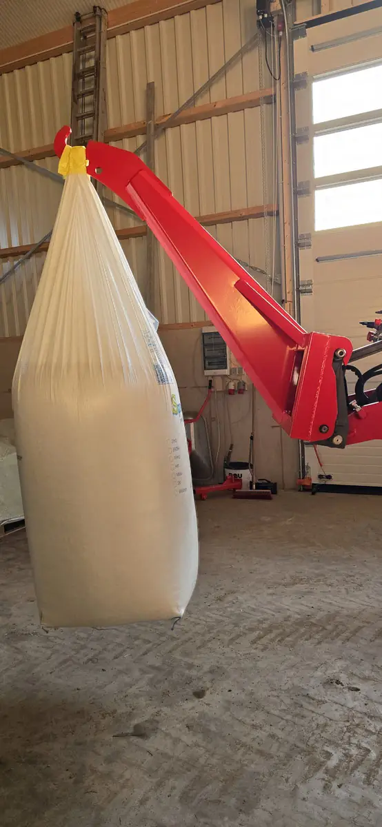 Big-Bag hängt frei am Lasthaken des Hubgalgens in der Werkstatt
