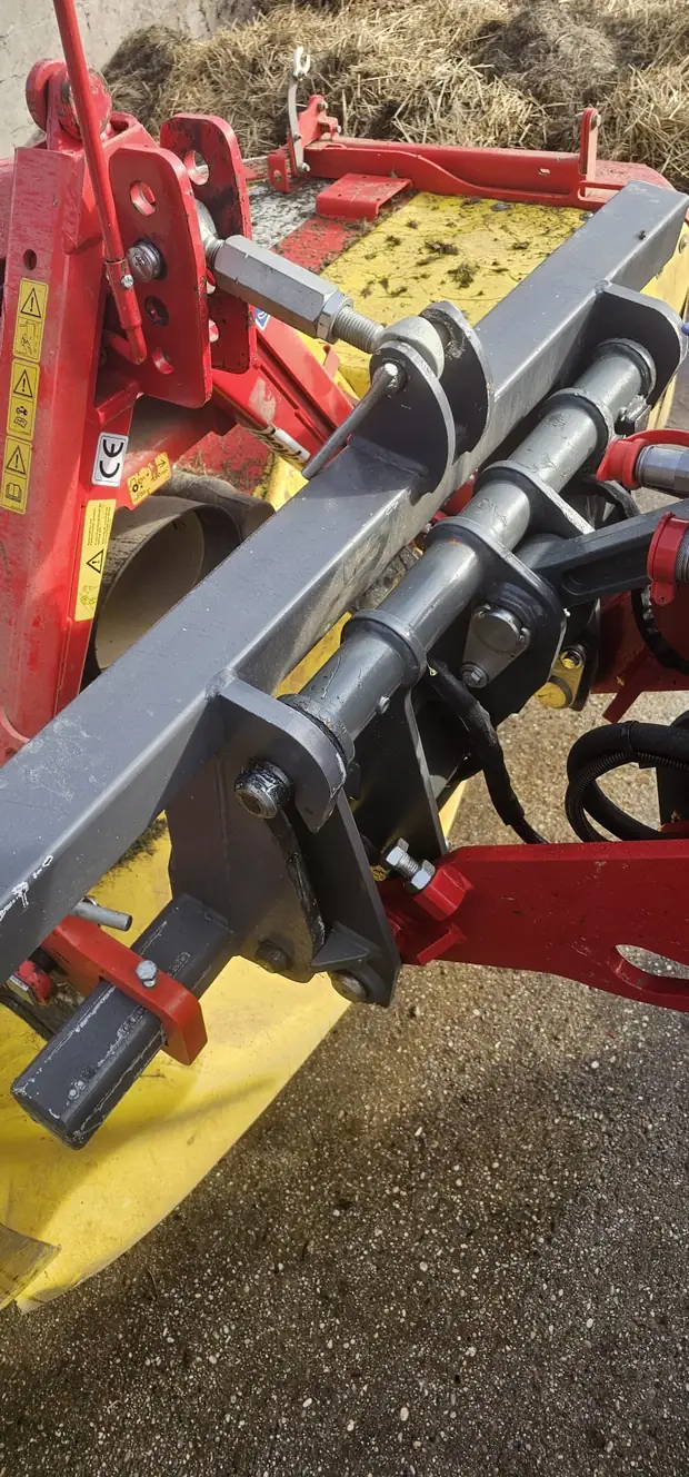 Dreipunkt-Anbaubock am Lader, daran ein Mähwerk angekoppelt