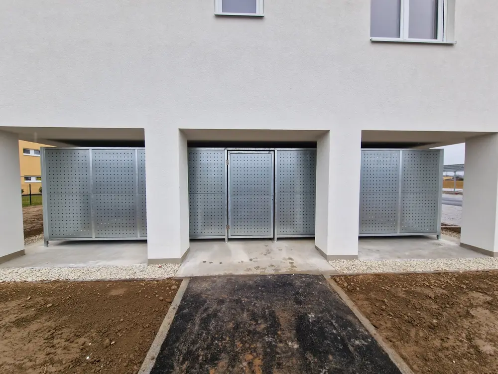 Einhausungen aus feuerverzinktem Lochblech im Erdgeschoss eines Wohnhauses, drei Felder nebeneinander