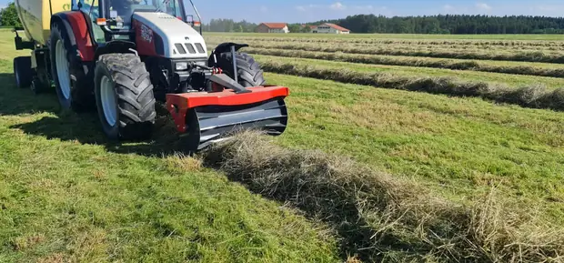 Schwadwalze am Traktor im Einsatz, die Walze fasst das Mähgut zum Schwad