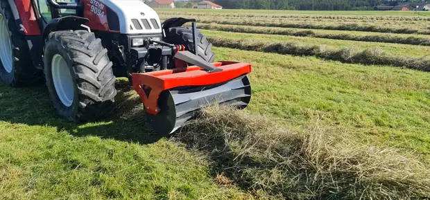 Schwadwalze am Traktor auf der Wiese, Schwaden im Hintergrund