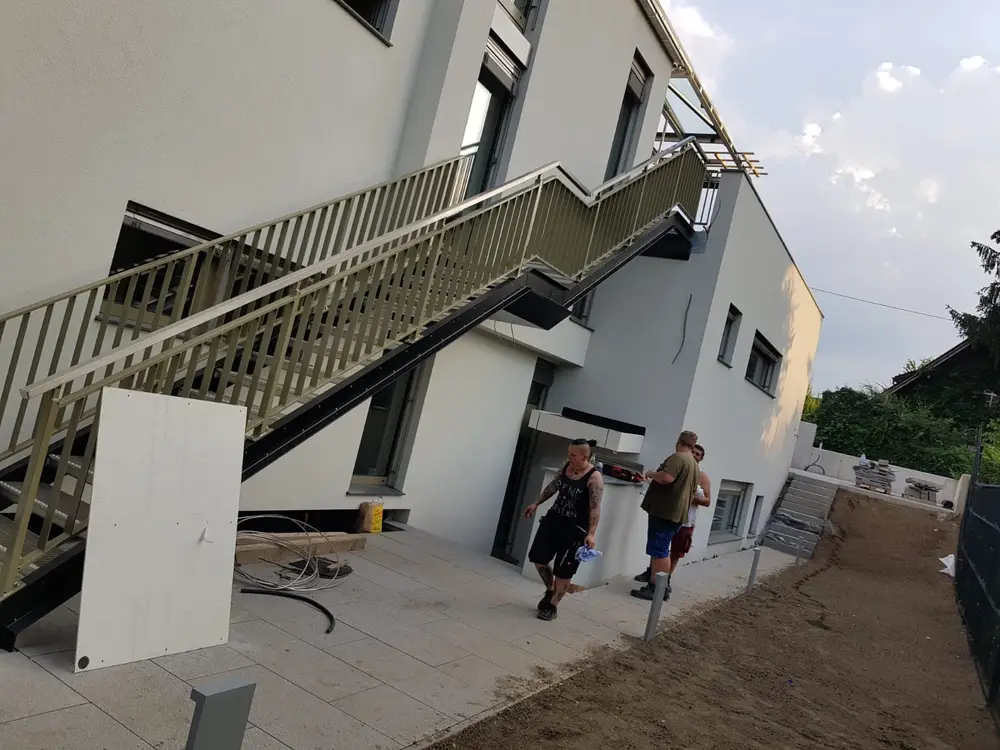 Zweiläufige Außentreppe mit Zwischenpodest an einem Neubau, Geländer mit senkrechten Stäben