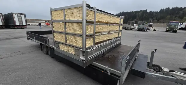 Beladener Anhänger mit Hühnerkisten auf zwei Untergestellen